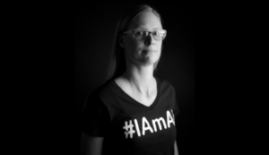 Charlotte Dungan standing in studio wearing a black tshirt with #IAMAI on the front